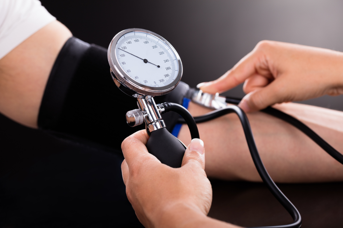 Person measuring blood pressure with a manual cuff to monitor how electrolyte balance affects heart health.
