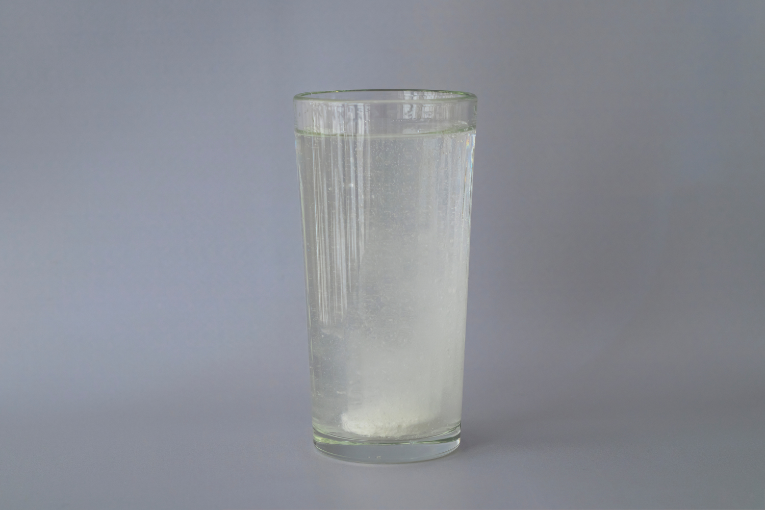 Glass of water with electrolyte tablet fizzing at the bottom