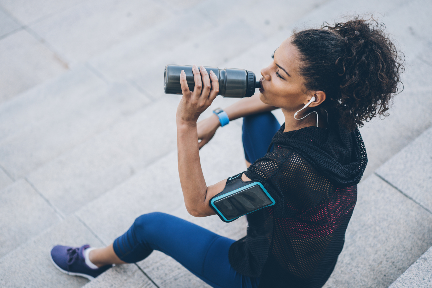 Active woman hydrating after run