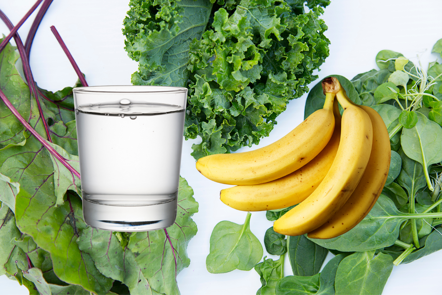 A glass of water and banana with leafy greens as background