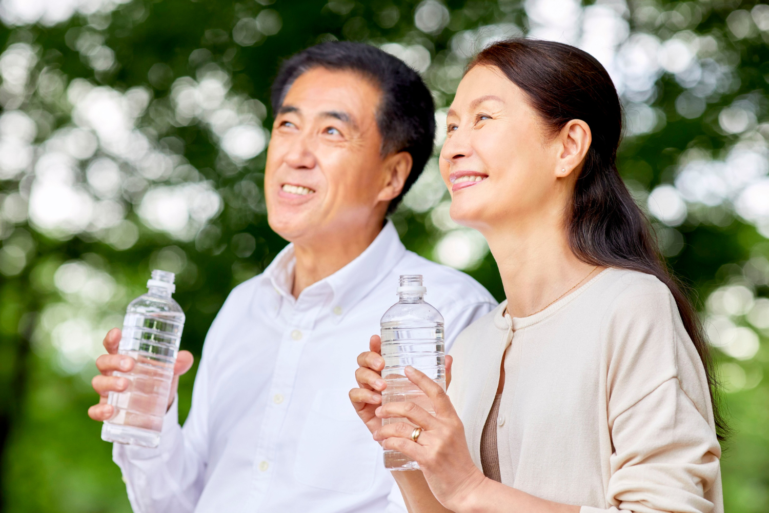 Elderly couple holding water bottle.