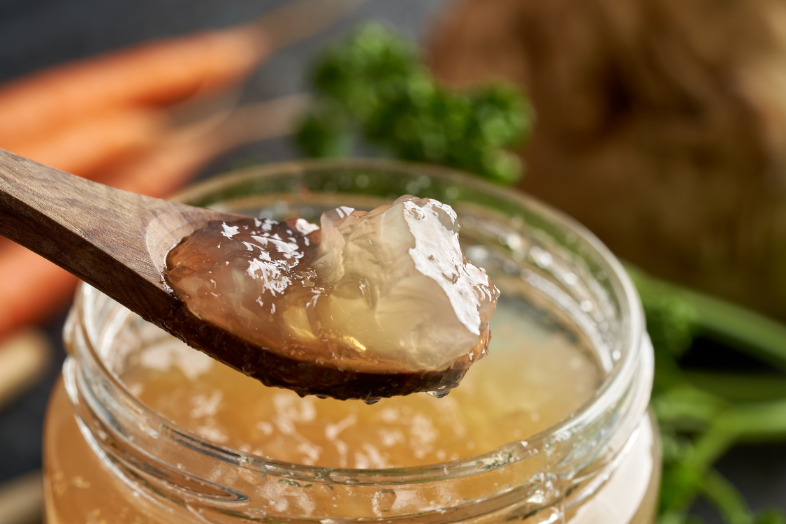 Spoon of gelatin-rich bone broth from a glass jar