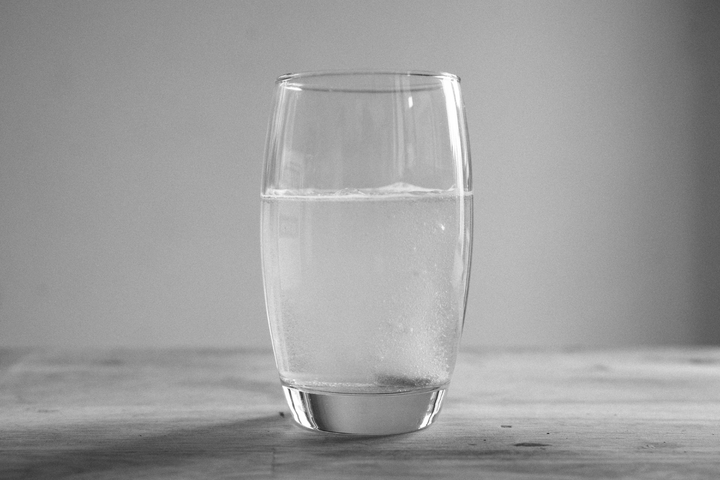 Glass of water presumably with electrolytes.