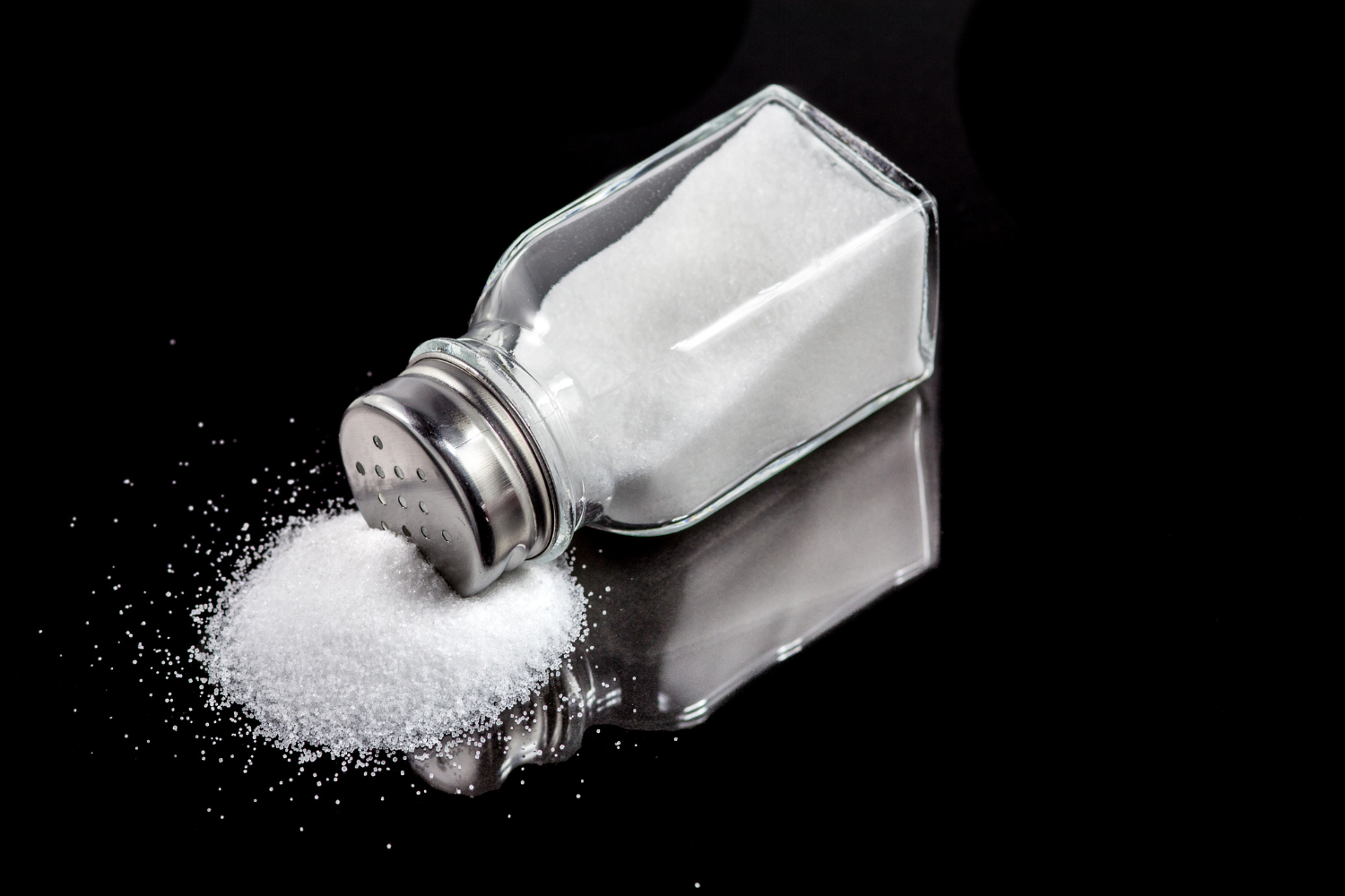 Salt shaker on black surface.