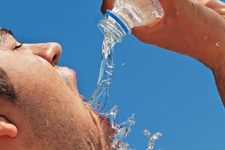 A person drinking water from a plastic bottle
