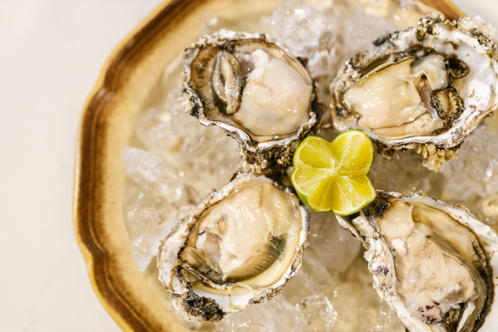 Plate of fresh oysters on top of ice.